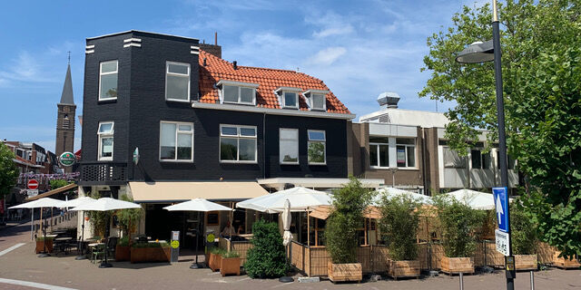 foto van het zonnige terras met witte parasols van Cafe de Slimmerick in Naaldwijk in het Westland