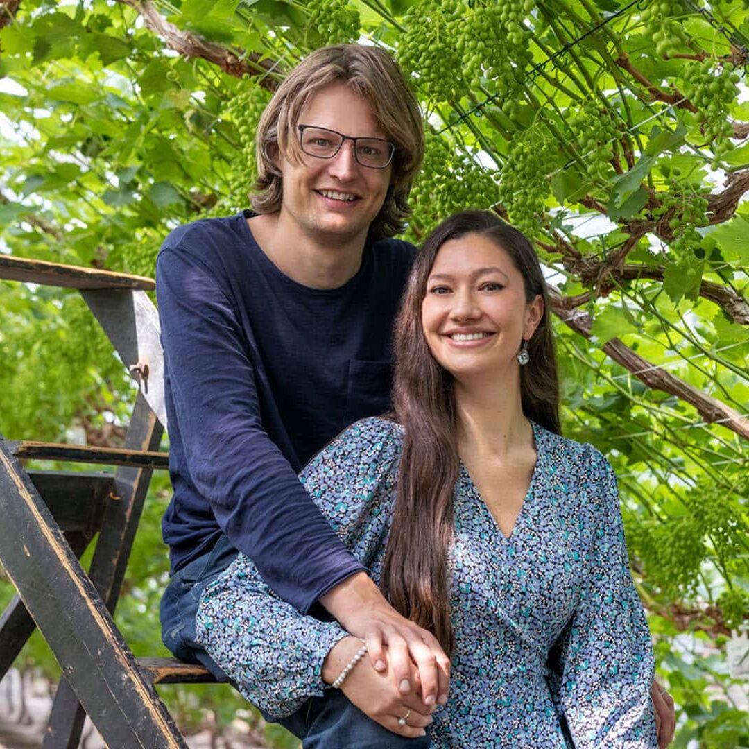 Sharon-Dewi en Tim op een ladder in de druivenkas van Druivenkwekerij Nieuw Tuinzight
