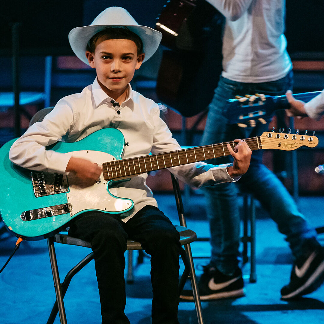 jongetje met cowboyhoed en groene gitaar treedt op tijdens een festival van westland cultuurweb in het westland