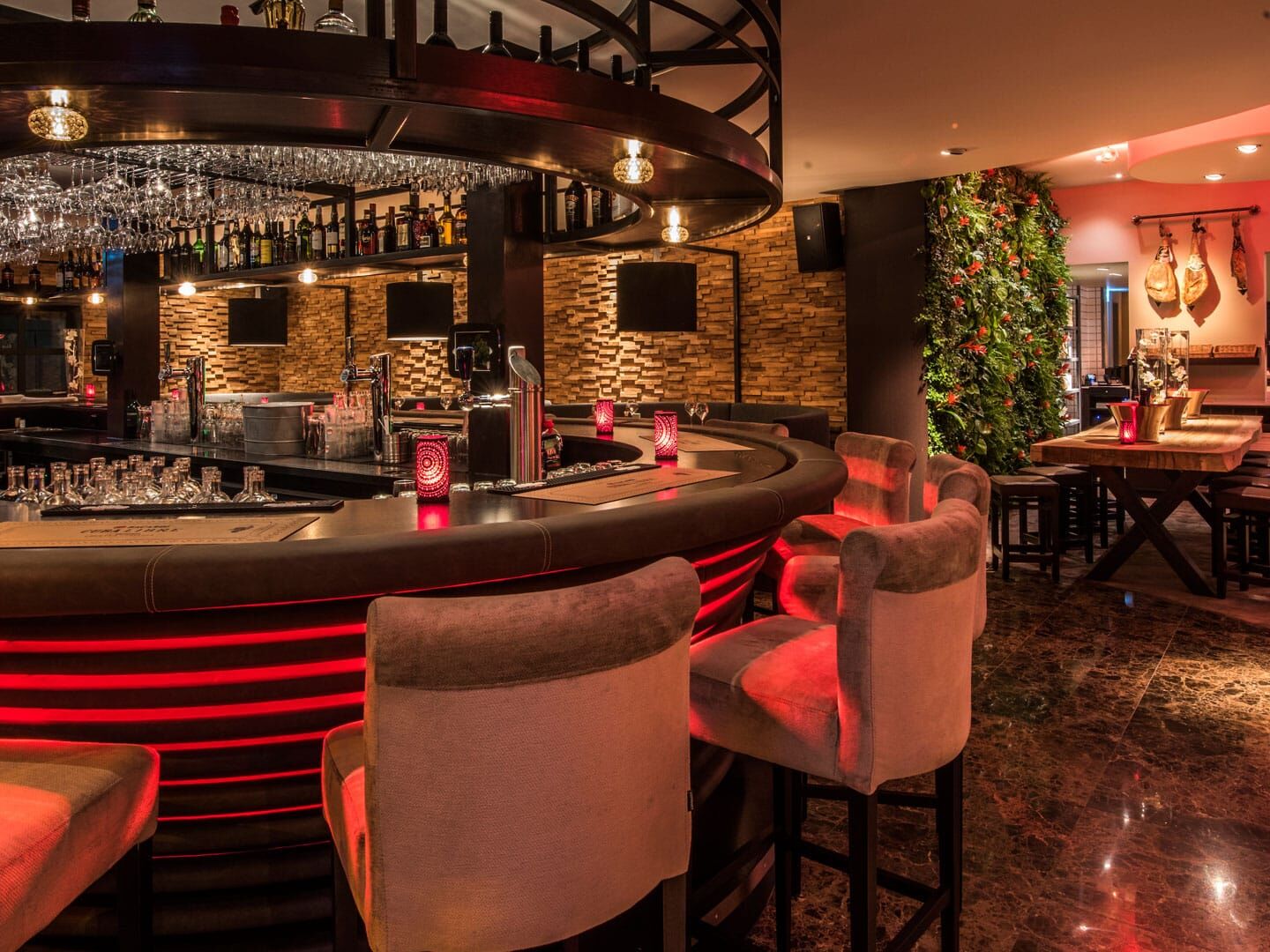 bar van Hotel Restaurant Unicum Elzenhagen in het Westland met hoge barstoelenn, een rond bar en rode ledverlichting