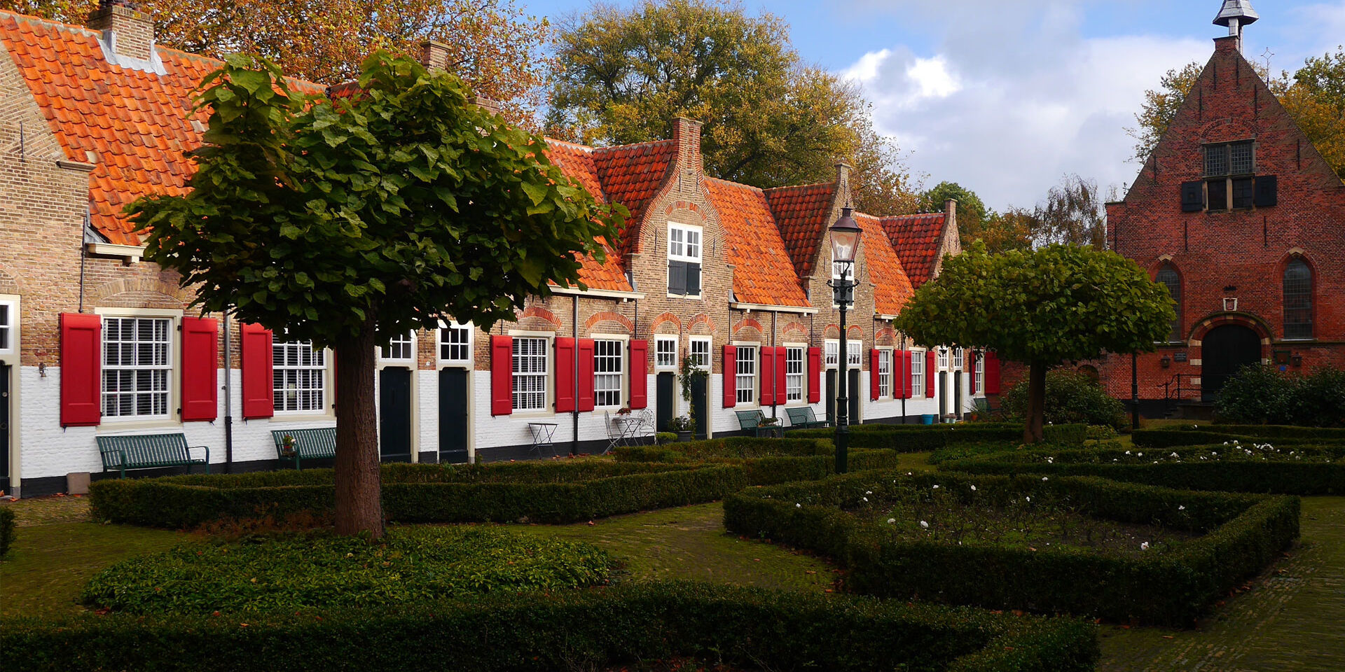 foto van oude huisjes met rode luiken en oranje daken in het Heilige Geesthofje in Naaldwijk in het Westland
