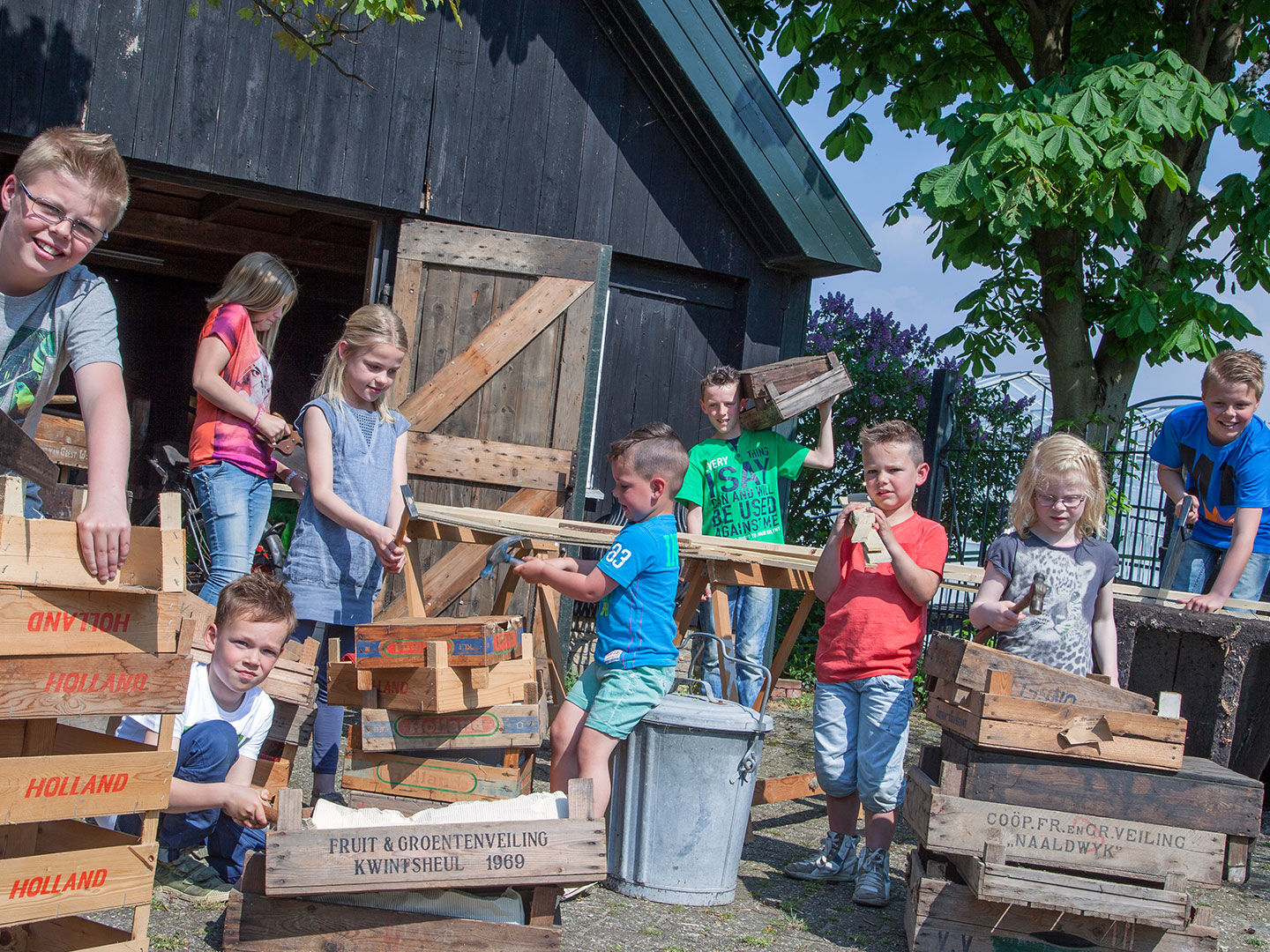 groepje jongens en meisjes zijn bezig met een timmerworkshop met houten druivenkistjes bij het Westlands Museum in het Westland