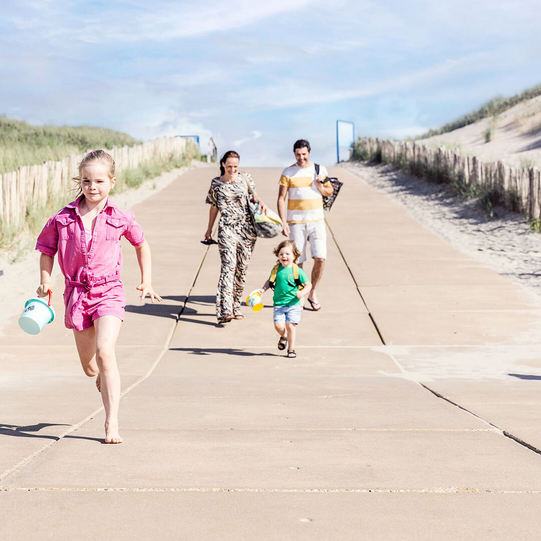 Gezin strand strandopgang westland meisje in roze gezin vakantie dagje strand Monster