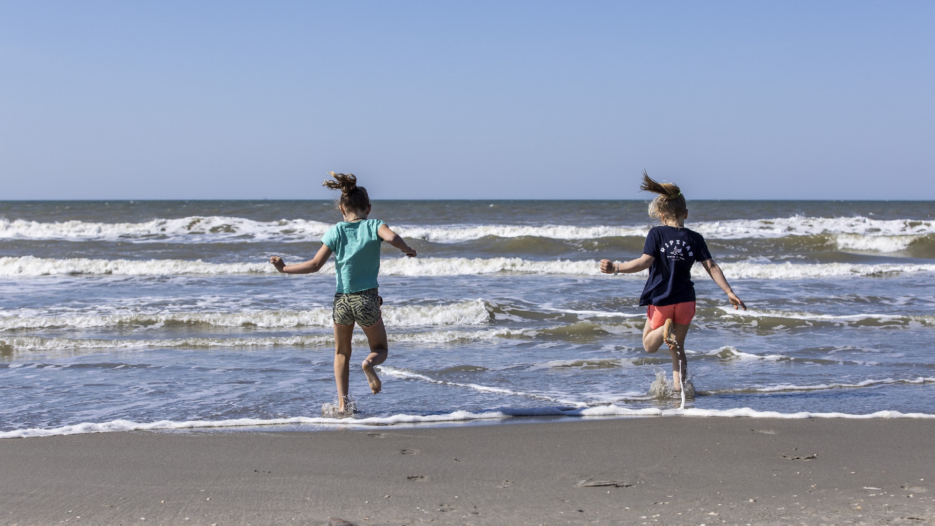 Kinderen rennen zee in aan Westlandse kust stranddag
