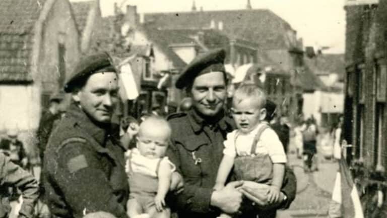 soldaten in WOII in De Lier met kleine kinderen op de arm en voor zich op straat fietsroute langs stille getuigen