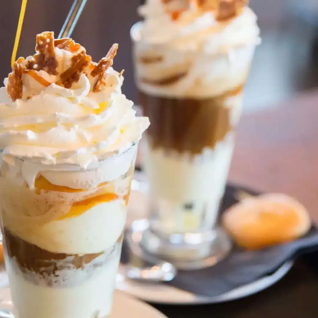 twee ijskoffie's in glazen coupes en een kopje koffie op een dienblad bij restaurant de buren in 's-gravenzande Westland