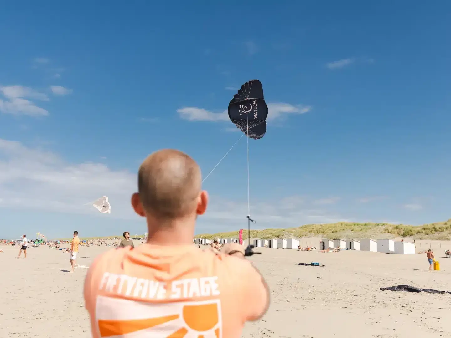 man met powerkite op het westlandse strand op een zomerse dag