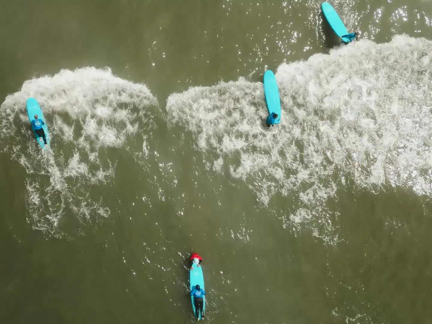 droneshot van surfers op zee in het westland